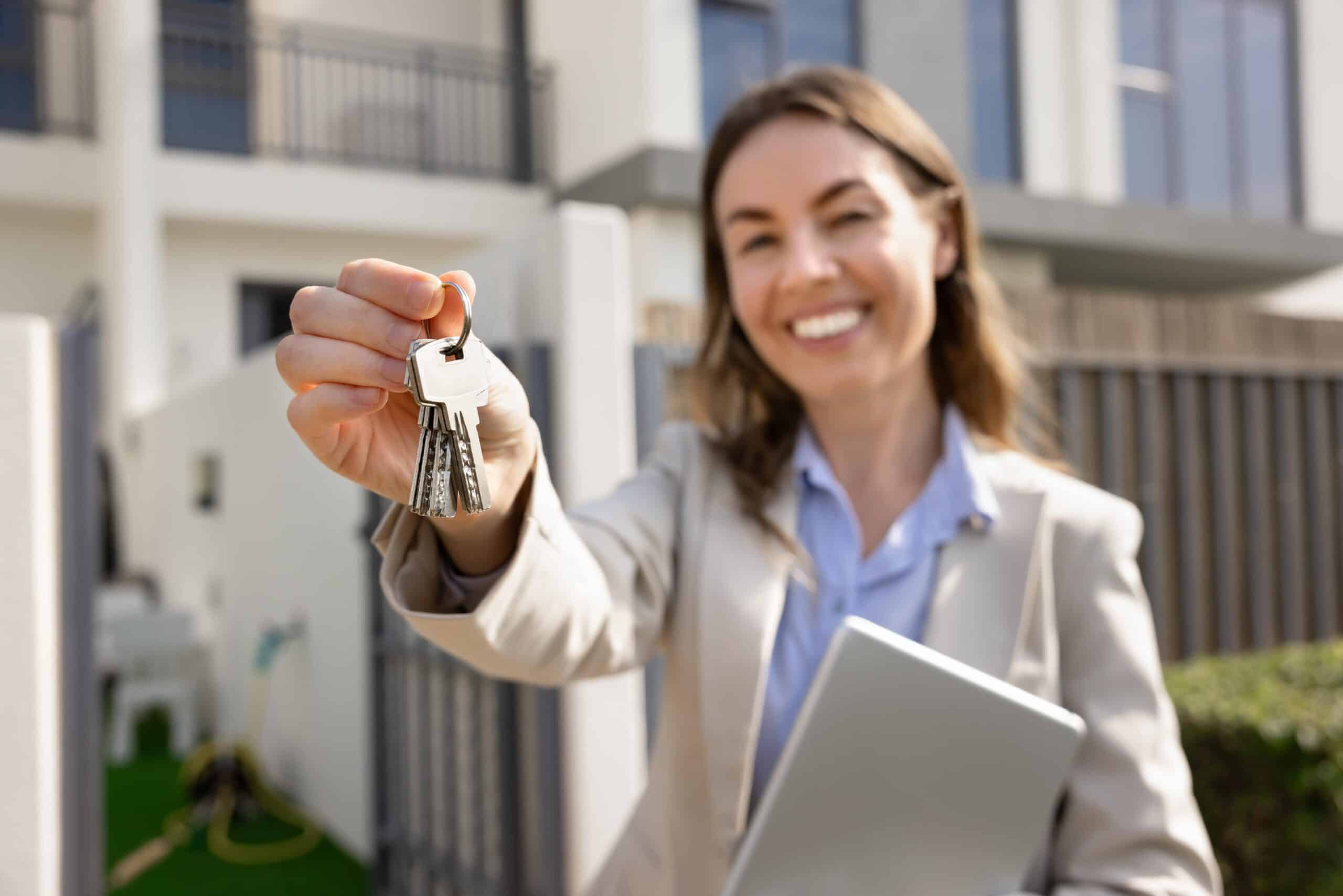 Smiling Female Property Manager Outside Property Holding Key Ring