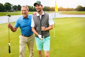 Happy Older Man and Young Man Golfing on Course at Country Club