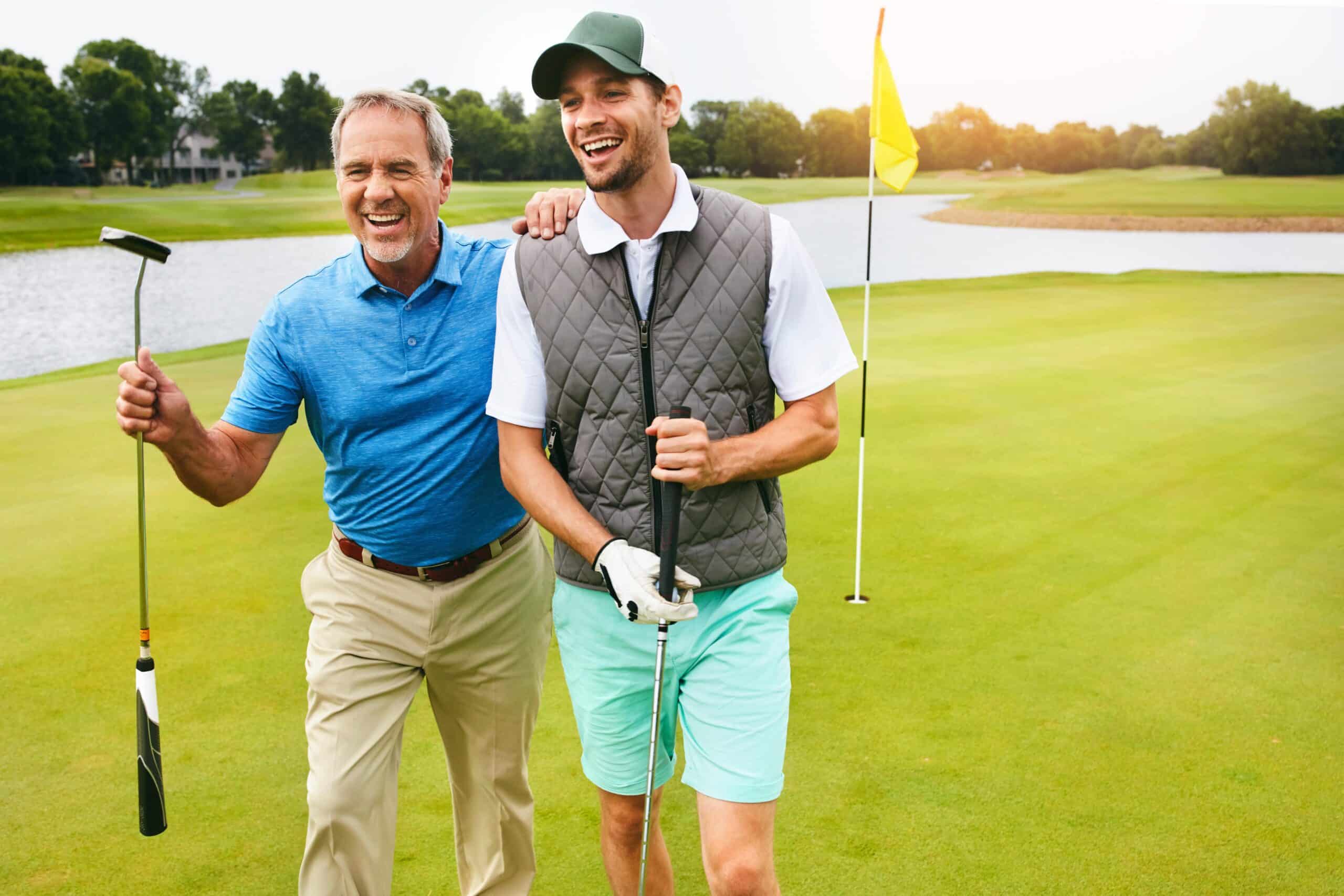 Happy Older Man and Young Man Golfing on Course at Country Club