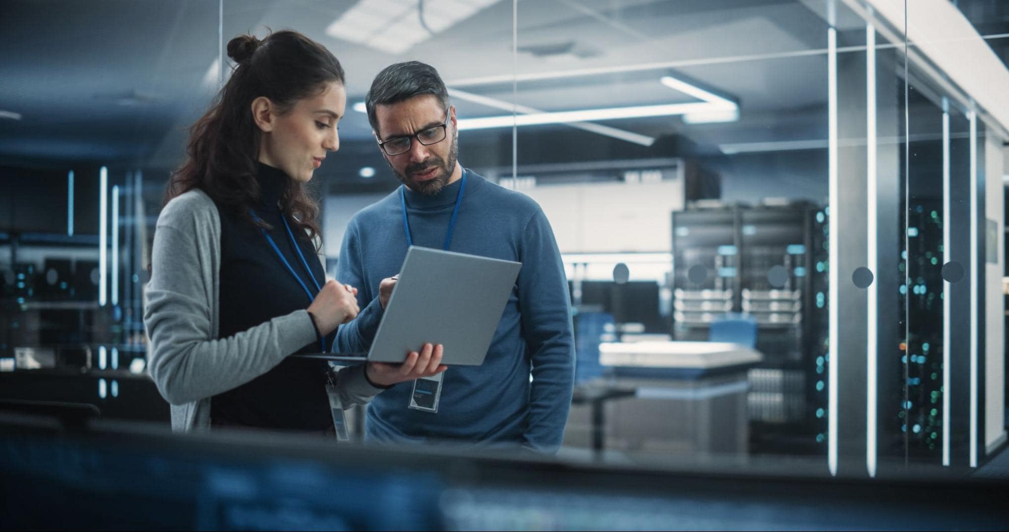 Male and female recruiter reviewing a laptop and discussing the data center talent shortage in office setting