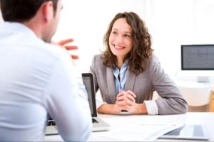 A hiring manager interviewing a candidate, discussing underwriter job description examples.