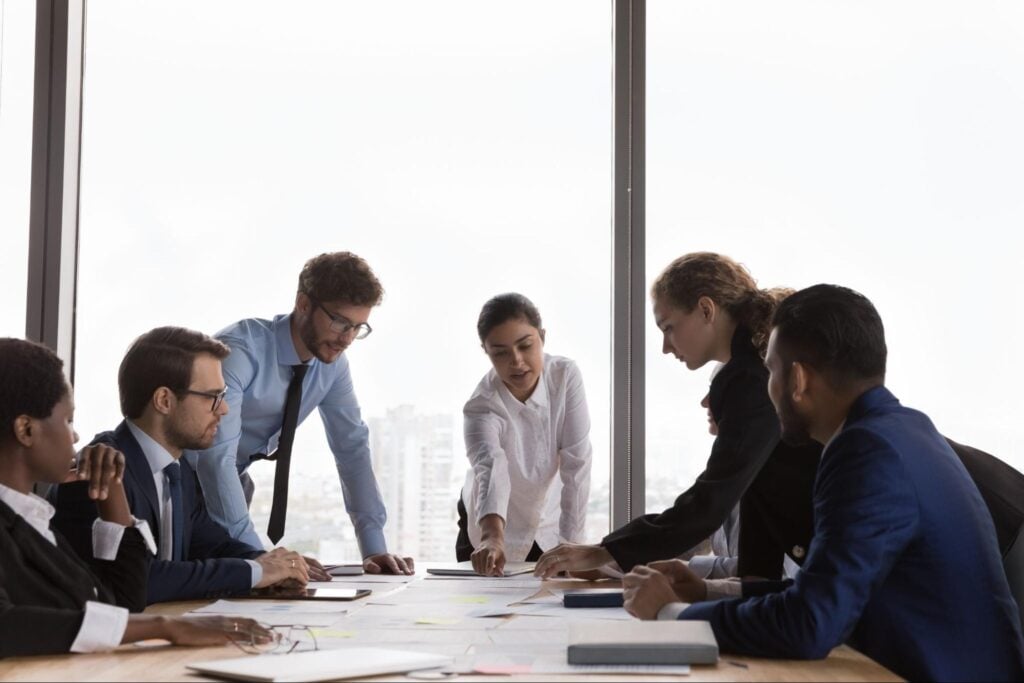 A diverse group of business leaders collaborating on documents for effective succession planning in a bright office.